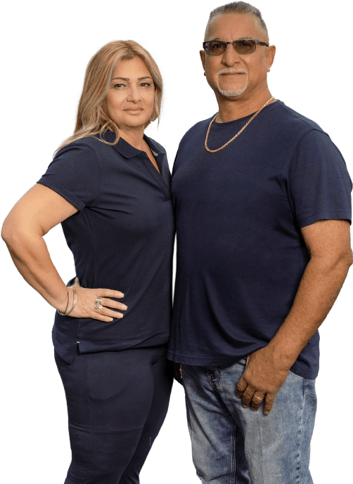 Photo of the owners of AJS Air, smiling in front of their company building.